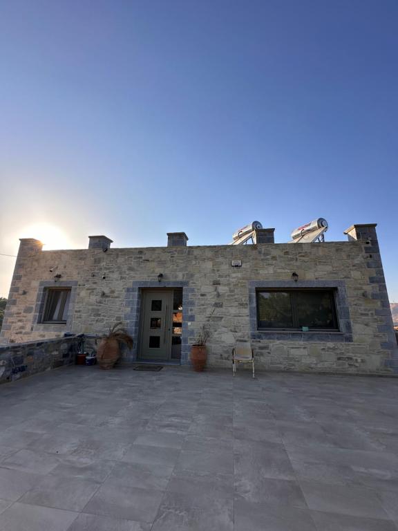 un edificio de piedra con un gran patio frente a él en Porti villas, en Áno Moúlia