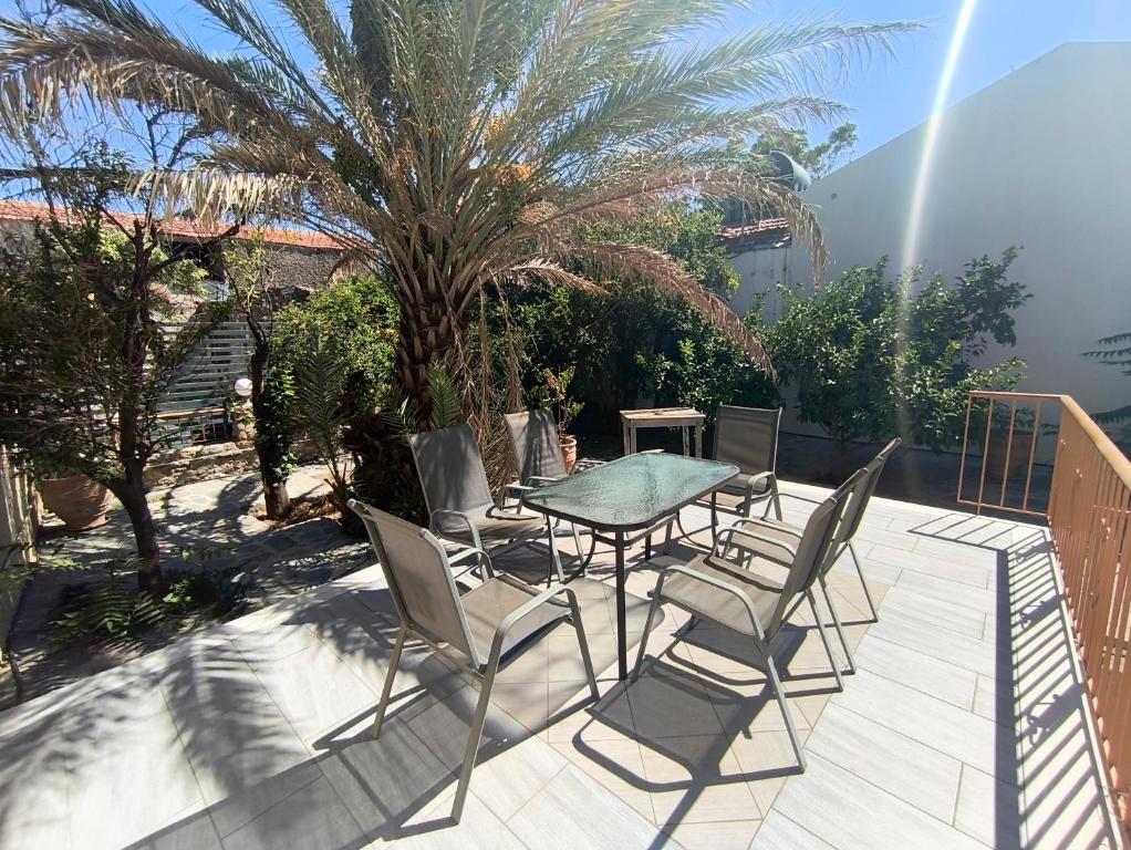 a patio with a table and chairs and a palm tree at JP Castle Resort in Chios