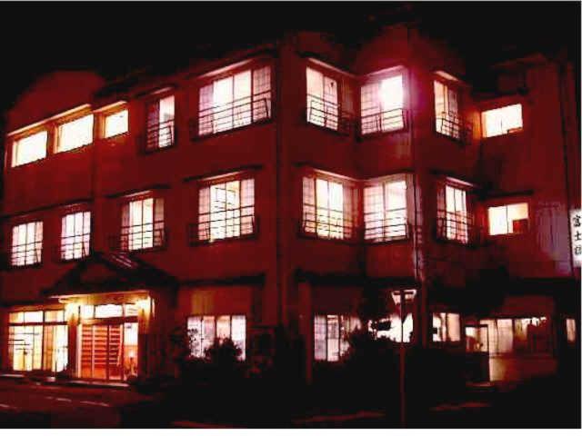 a large building with lit up windows at night at Resort Inn Fujihashi in Fujikawaguchiko
