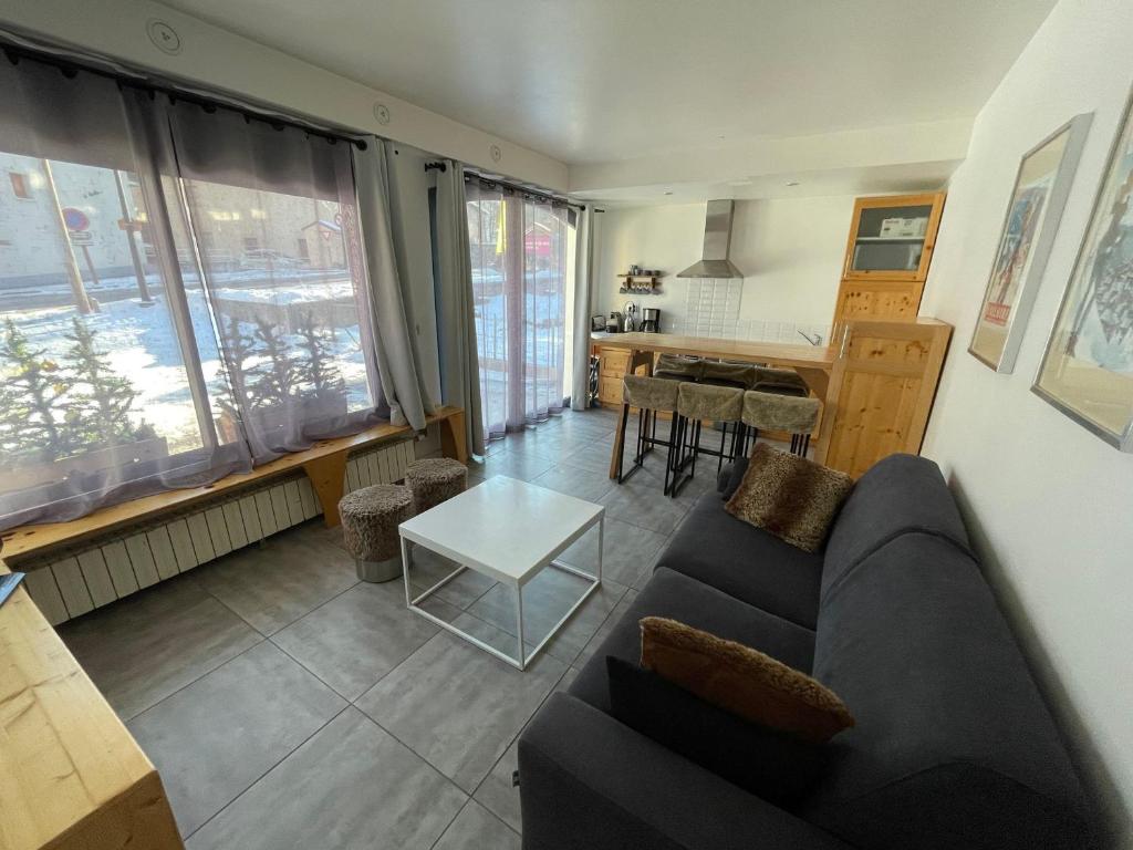 a living room with a couch and a table at Charmant T2 pour 4 pers avec Sauna, WiFi et Parking privé - FR-1-263-88 in Valloire