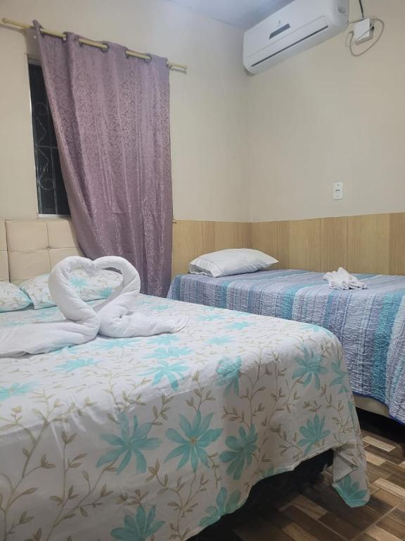 two beds with towels on them in a room at Sossego Meu in Soure
