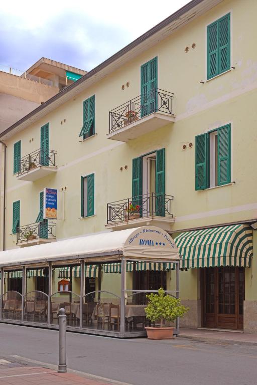 a building with a bus parked in front of it at Albergo Ristorante Roma in Arma di Taggia