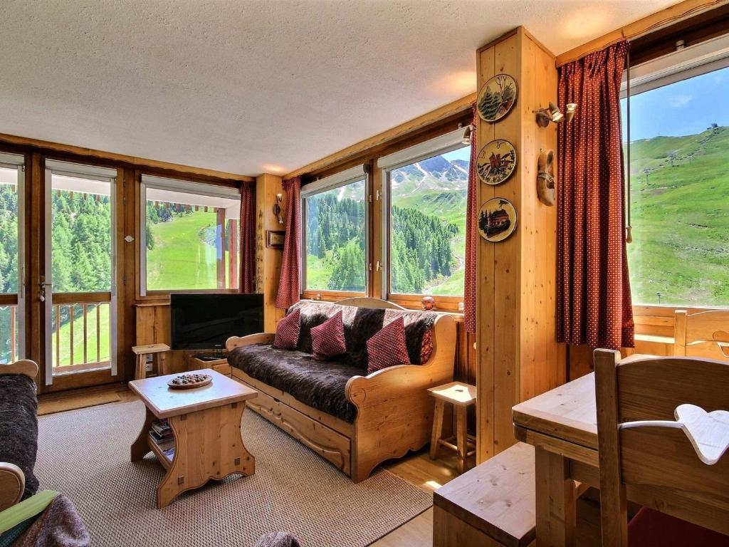 a living room with a couch and some windows at Grand appartement au pied des pistes avec balcon, pour 6 personnes - FR-1-455-40 in La Plagne