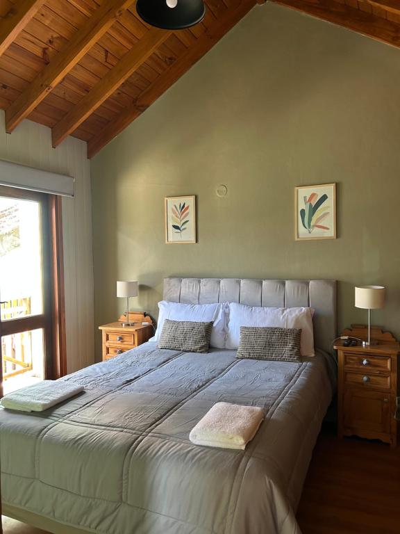 ein Schlafzimmer mit einem großen Bett mit zwei Nachttischen in der Unterkunft Cabaña Amancay, comodidad y tranquilidad a pasos del centro - Ayres del Bosque Alojamientos in San Martín de los Andes