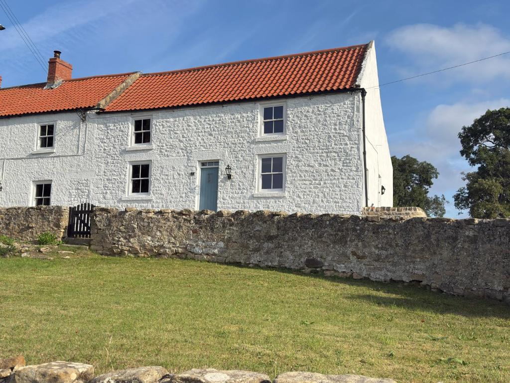 a white stone house with a red roof at Peace Cottage in Darlington