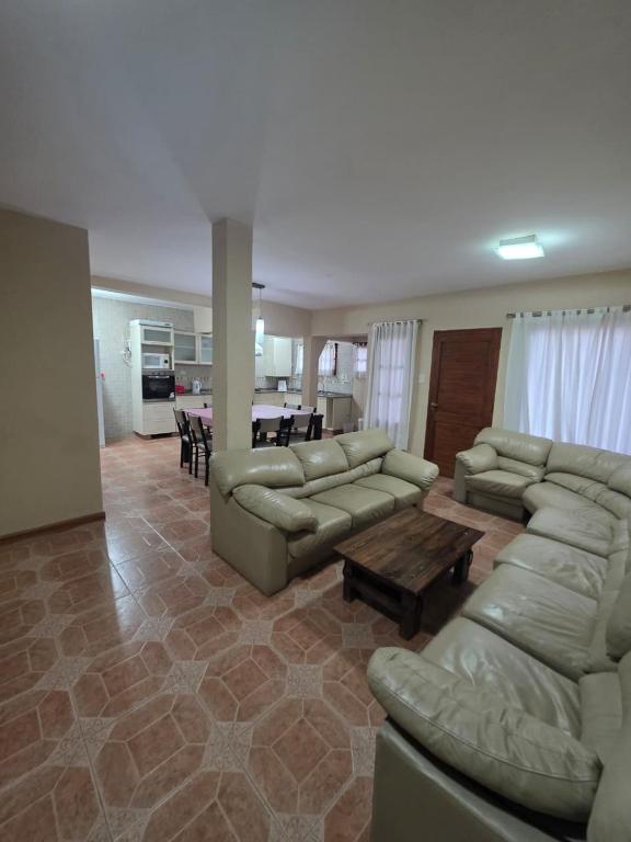 a living room with couches and a table and a kitchen at Casa nueva centrica in San Rafael