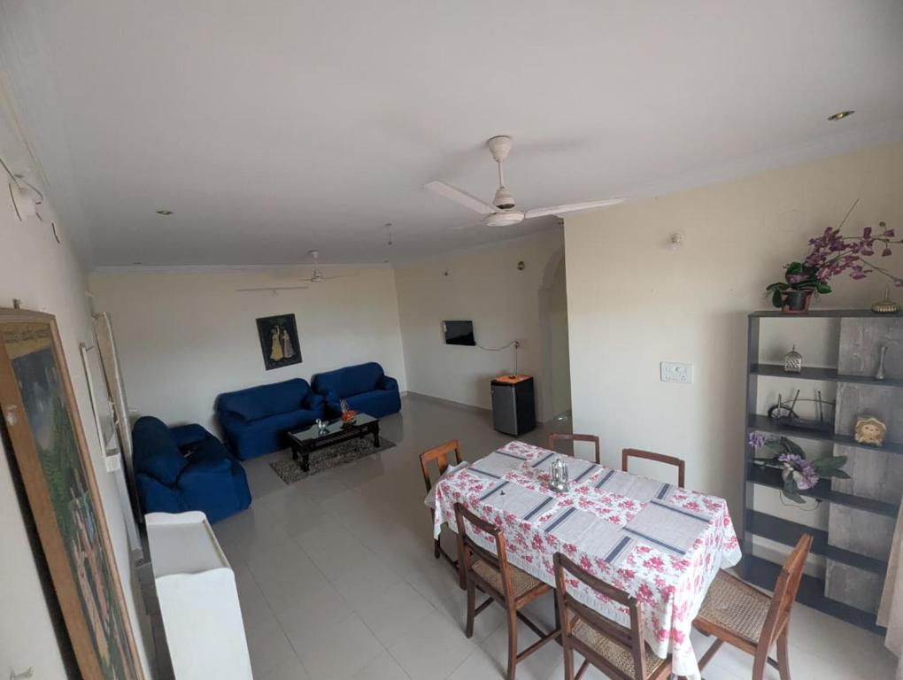 a living room with a table and a blue couch at Urban Dreamspace 2BHK fully furnished in Secunderabad