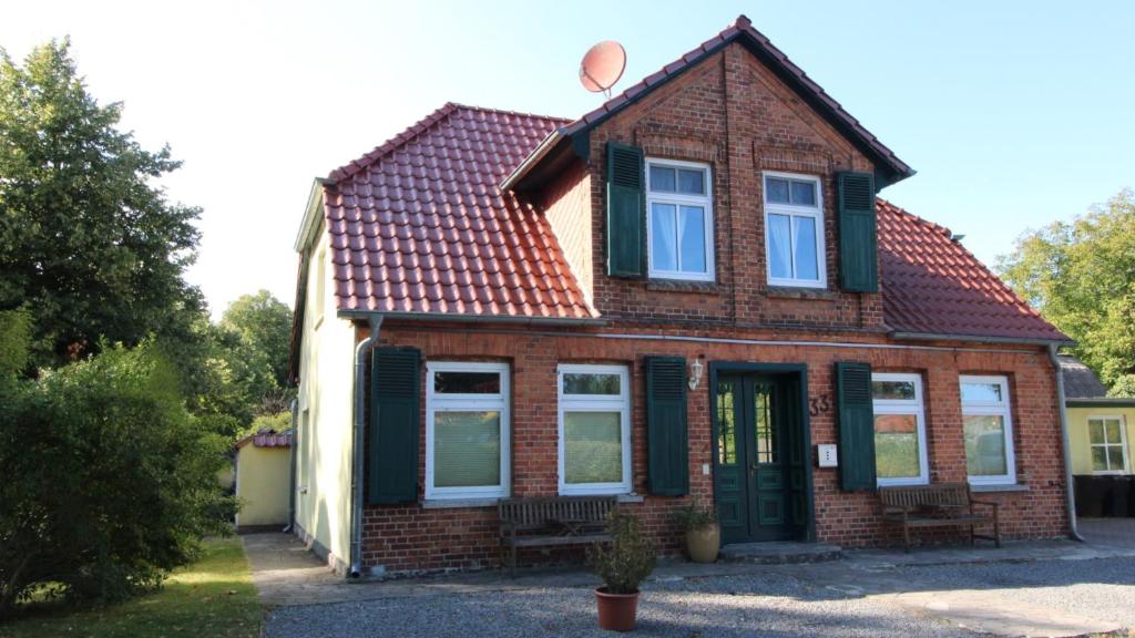 una casa in mattoni rossi con tetto rosso di Kapitänshaus FW 2 EG re a Wustrow