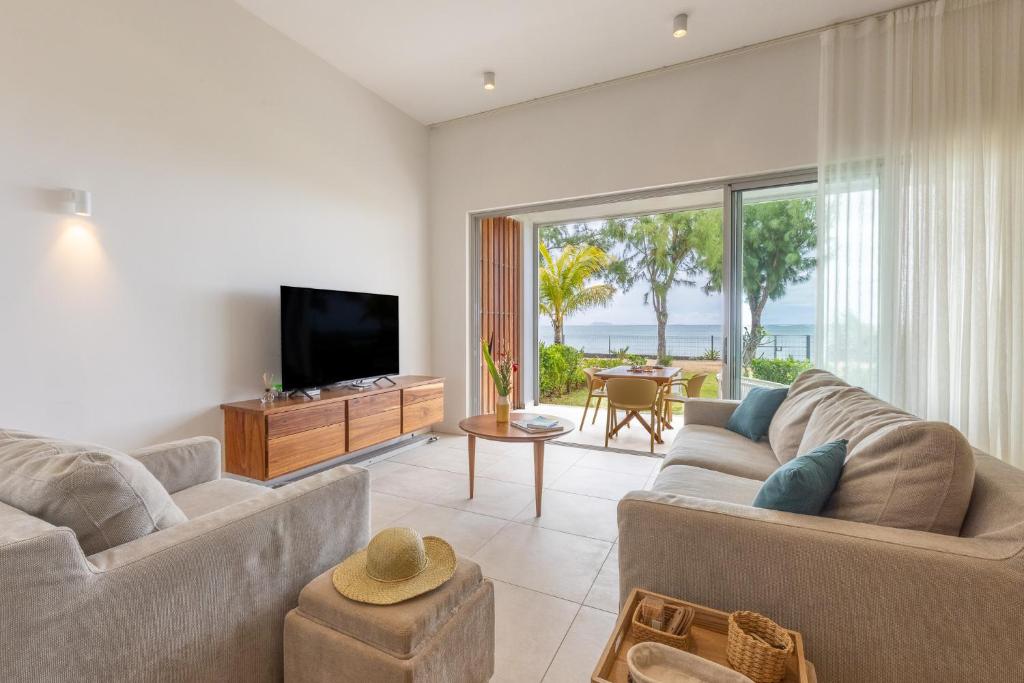 Μια τηλεόραση ή/και κέντρο ψυχαγωγίας στο Oceanview Escape - Beachfront Apartment