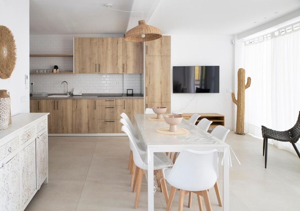 Una cocina y un comedor con mesa y sillas. en Gran apartamento Sorolla, en Playa de Miramar