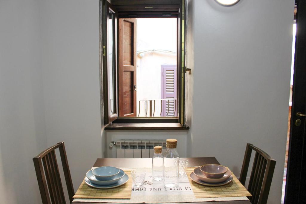 a table with plates and glasses on it with a window at Santa Rufè in Santa Rufina