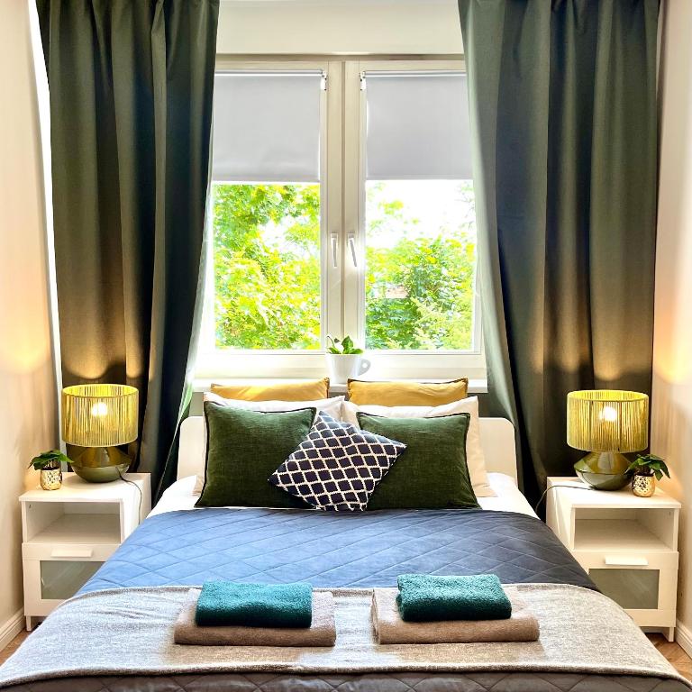 a bedroom with a large bed with two windows at Garone in Gdańsk