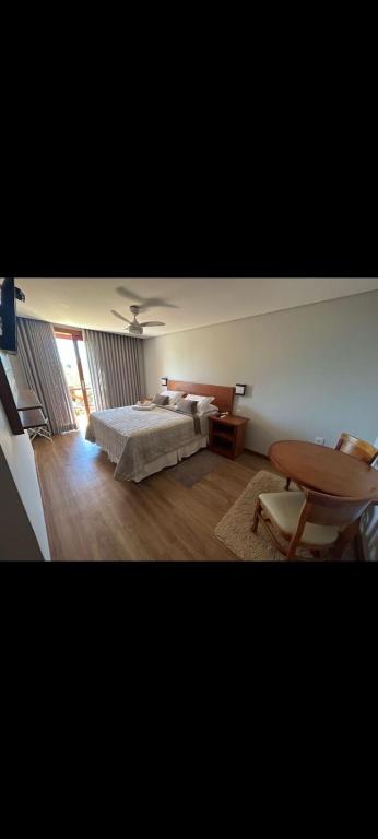 a bedroom with a bed and a table at Pousada Carumbé Lavras Novas in Lavras Novas