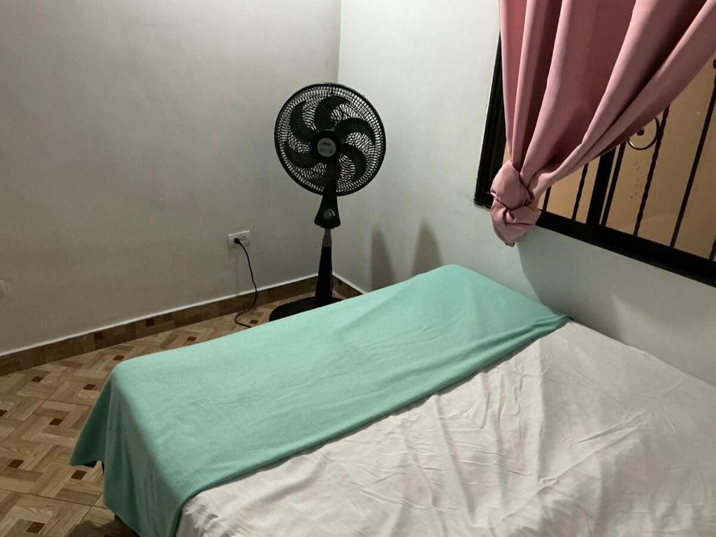 Camera con letto, ventilatore e finestra. di Aparta suite Torre de Prado 402 a Medellín