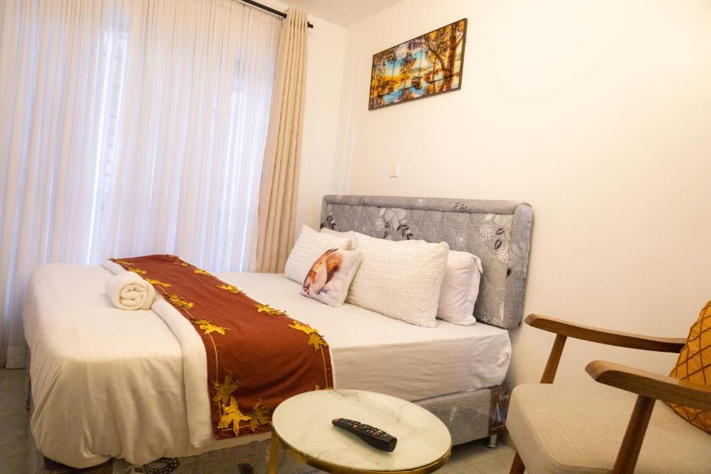 a bedroom with a bed with a remote control on it at Nyabush fedha comfort suites in Nairobi