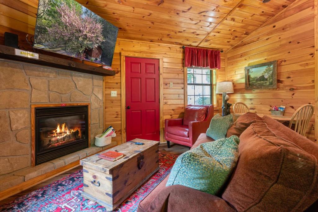 a living room with a fireplace in a log cabin at Comforts Me Hot Tub in Sevierville