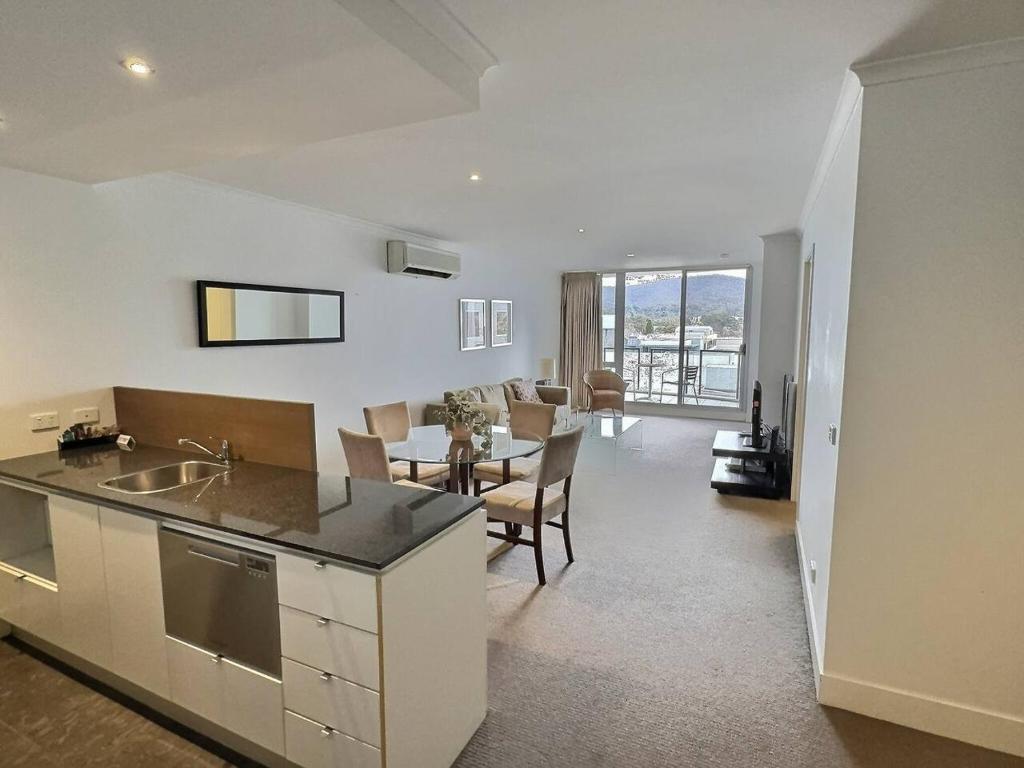 a kitchen and living room with a table and a dining room at City Centre Apartment 17 in Turner