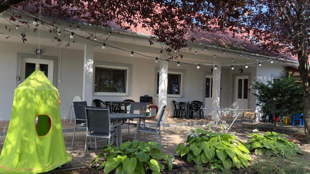 a patio with a table and chairs and a house at Heera Apartman in Hajdúszoboszló
