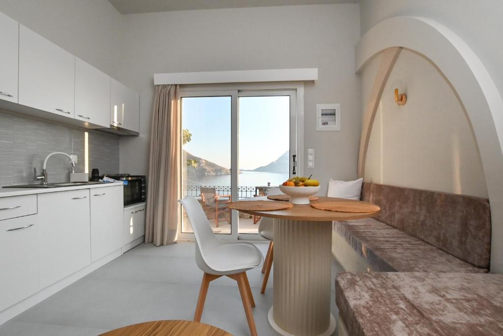 a kitchen with a table with a bowl of fruit on it at Skalia Mountain & Sea Suites in Skaliá