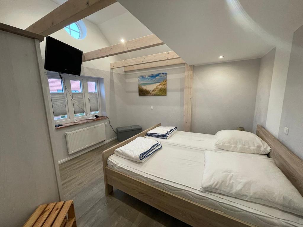 ein Schlafzimmer mit einem Bett und einem TV in der Unterkunft Ferienhaus Swinemünde mit Sauna und Whirlpool exkl buchbar in Tönning