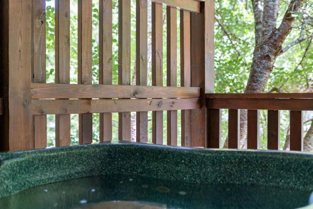 a wooden fence with a tub in front of a tree at In Green Pastures Gatlinburg in Sevierville
