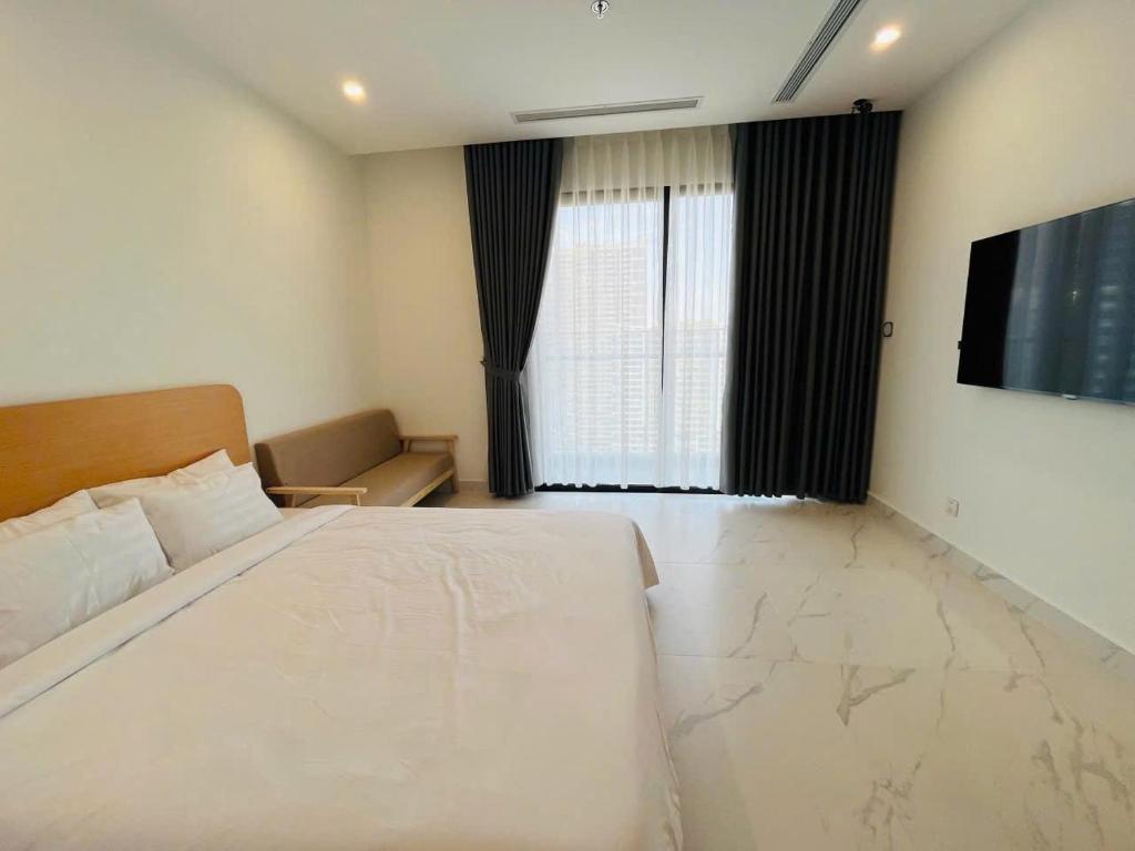 une chambre avec un grand lit et une télévision à écran plat dans l'établissement SEN Vinhome Grand Park Q9, à Long Bình