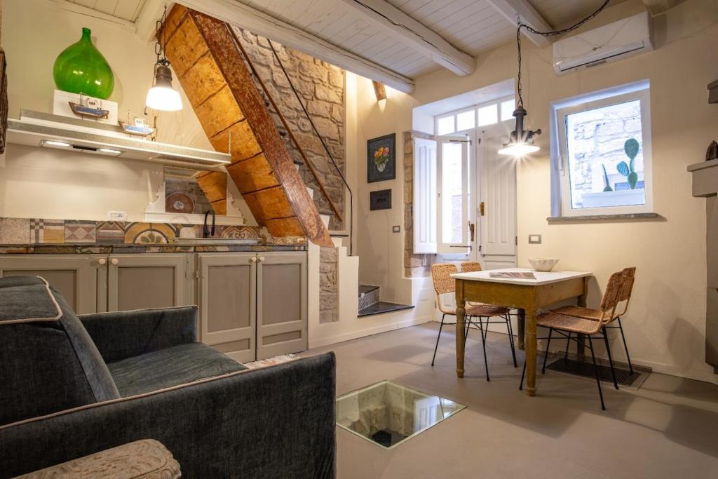 a kitchen and living room with a table and chairs at Casa Ancora in Carloforte