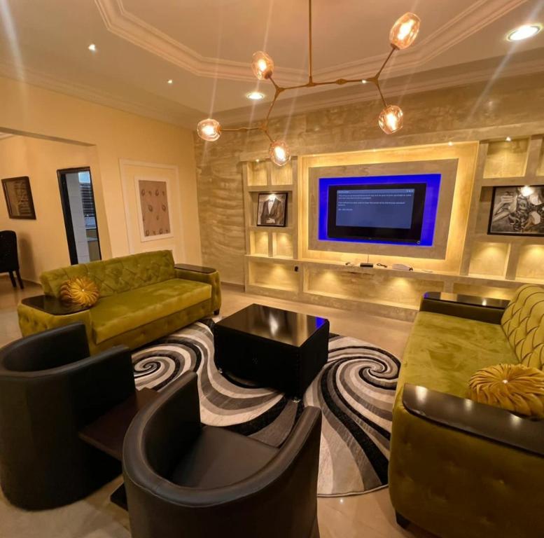 a living room with couches and a flat screen tv at Kaycee Apartments, Gym Swimming pool in Abuja