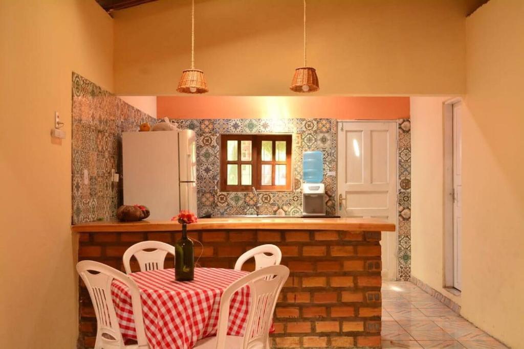 a kitchen with a table and chairs and a refrigerator at Casa Santos in Santo Amaro