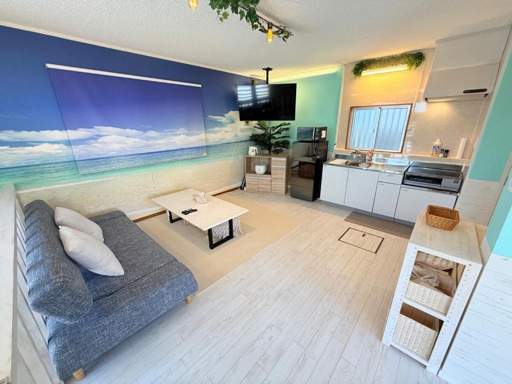 a living room with a couch and a kitchen at mini villa in Nago