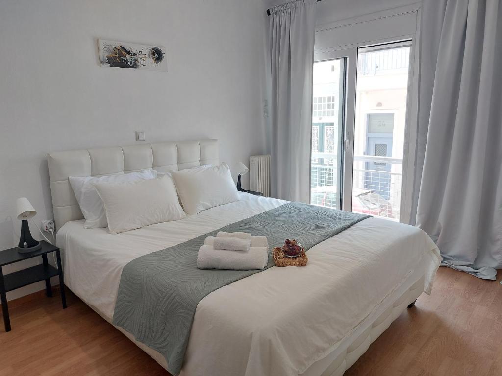 a white bed with a towel and a stuffed animal on it at Panpan Beach comfort home in Piraeus