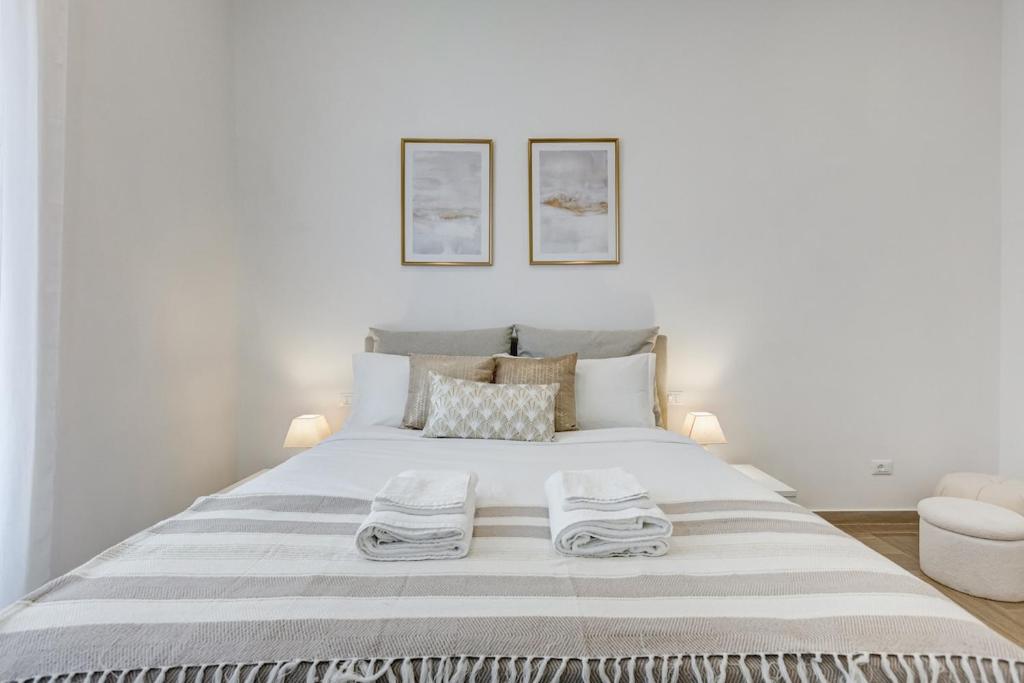a white bedroom with a large bed with towels on it at FaMa - Mecenate 3BR & 2BA in Rome