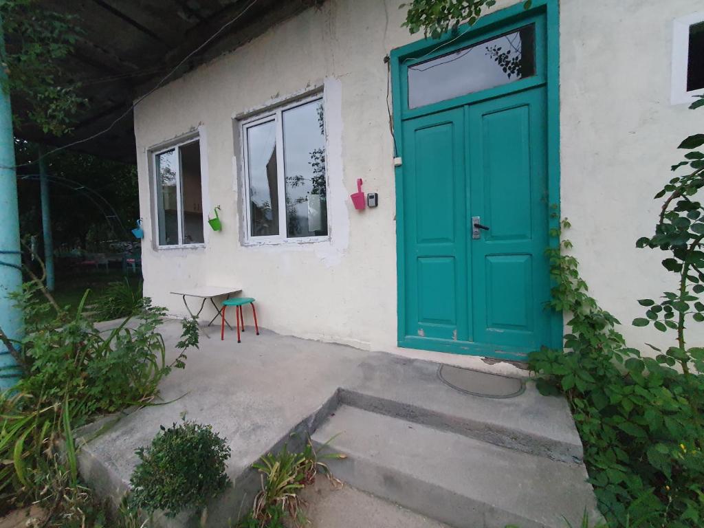 a green door on the side of a house at Певчая птица in Dilijan