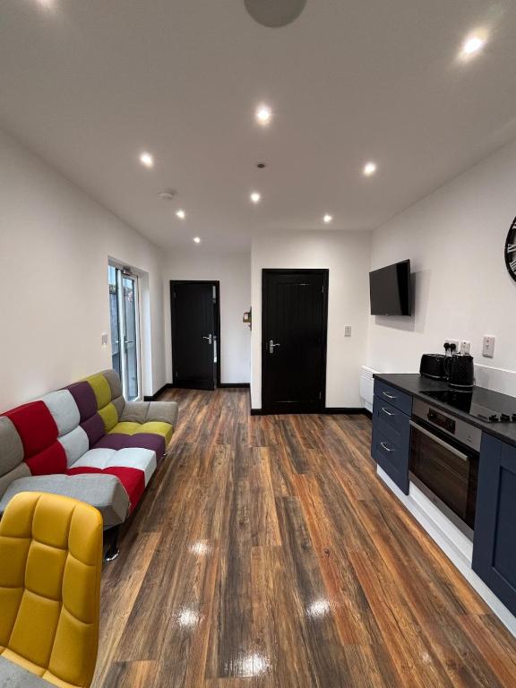a living room with a couch and a kitchen at The Cosy Cabin, Cookstown in Cookstown