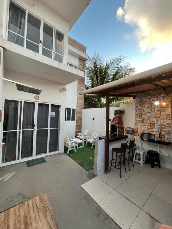 a patio of a house with chairs and tables at Casa paraíso dos milagres in São Miguel dos Milagres