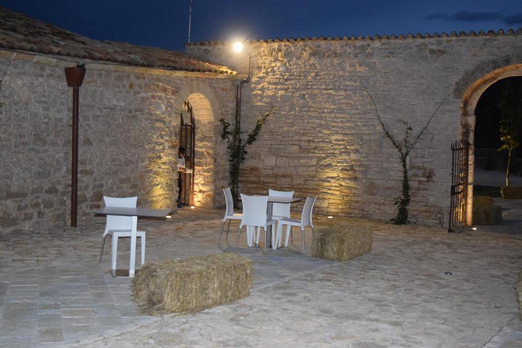 a group of white chairs and tables in a brick building at Masseria Revinaldi in Castel del Monte