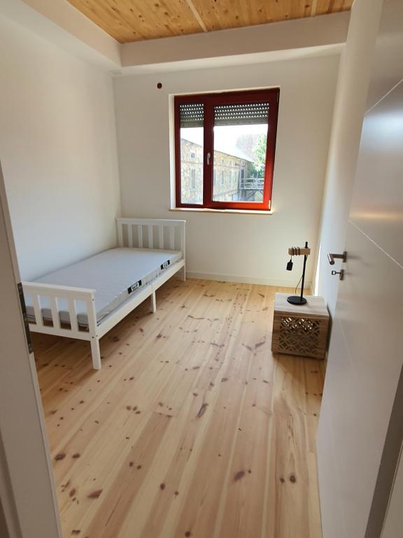 a bedroom with a bed and a wooden floor at Energiehof Liebon in Göda