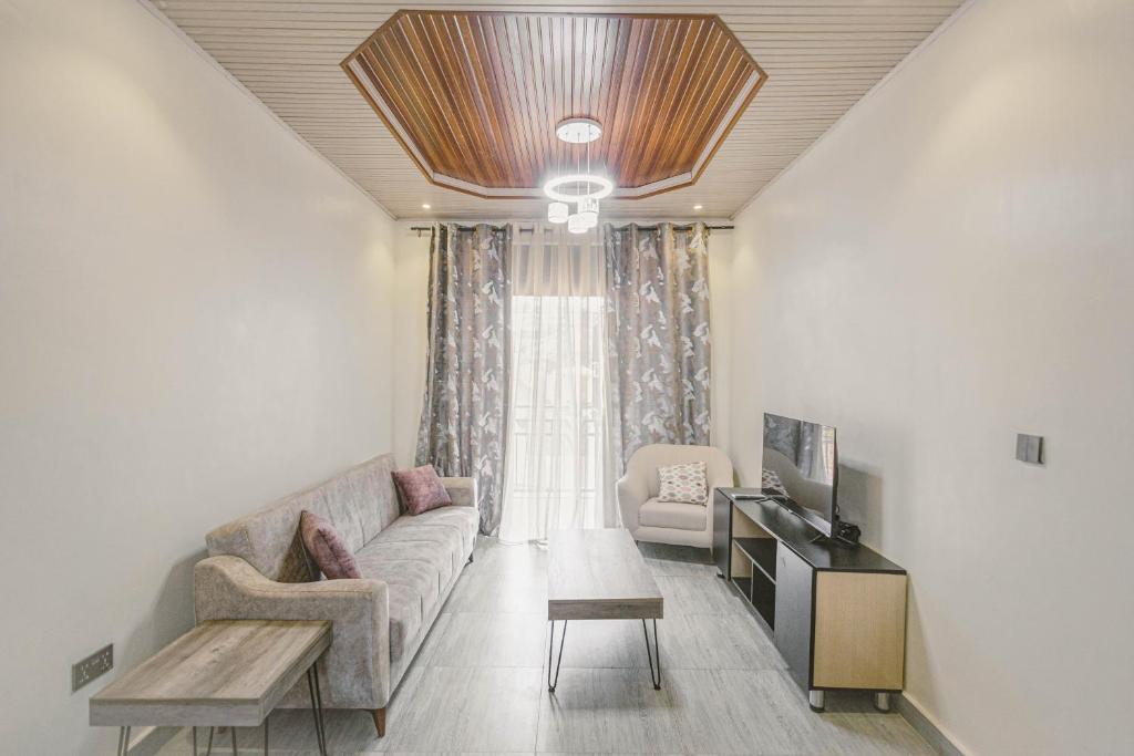 Una sala de estar con un sofá y un televisor. en 2 bedroom apartment with a smart TV and Wi-Fi 15 mins from downtown Kigali, en Kigali