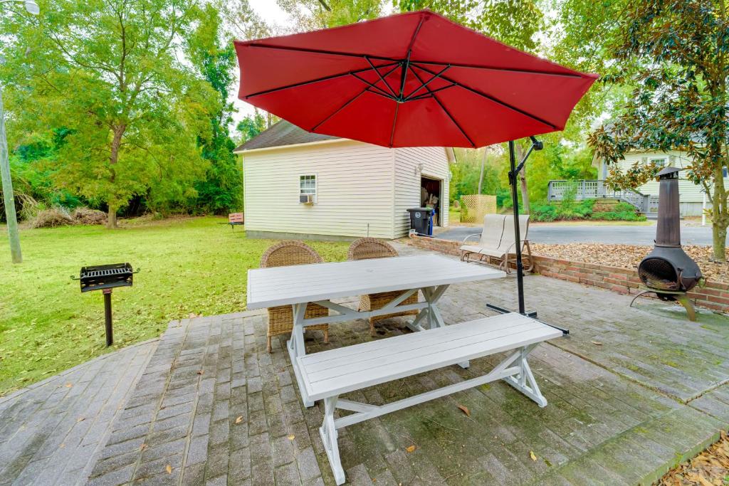 a picnic table with a red umbrella and a bench at Hike and Bike On-Site Burgaw Apt - 4 Mi to River in Burgaw