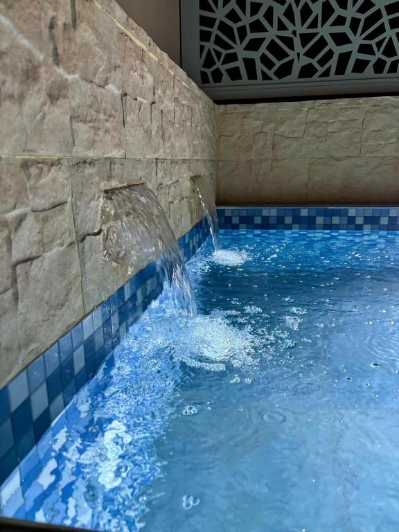 a swimming pool with a water fountain in a building at Dar Diaft'na in Marrakesh