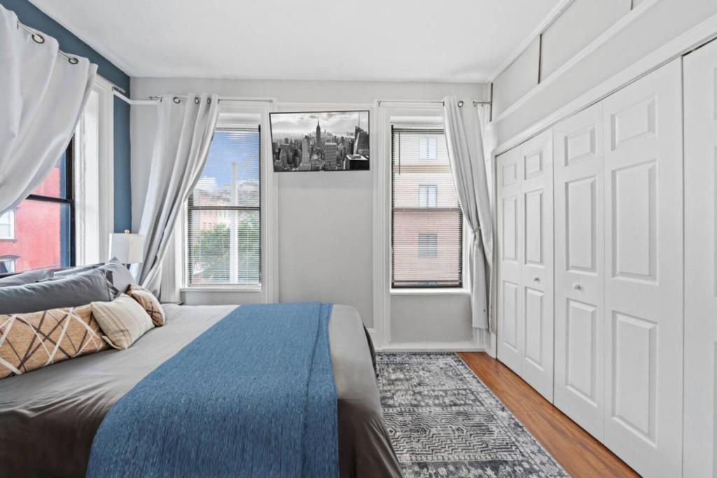 a bedroom with a blue bed and a window at Hoboken 15 Min Train to Manhattan Full Kitchen in Hoboken