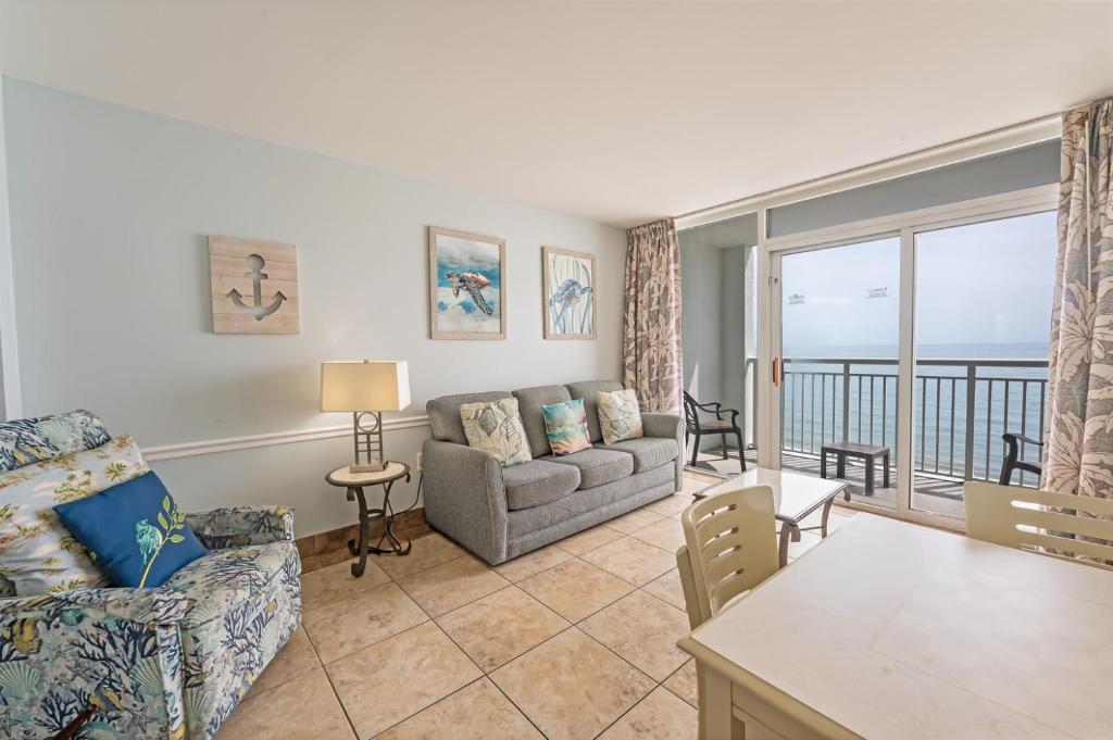 uma sala de estar com um sofá e uma mesa em Honeymoon Suite, Direct Oceanfront Suite, Pools! em Myrtle Beach