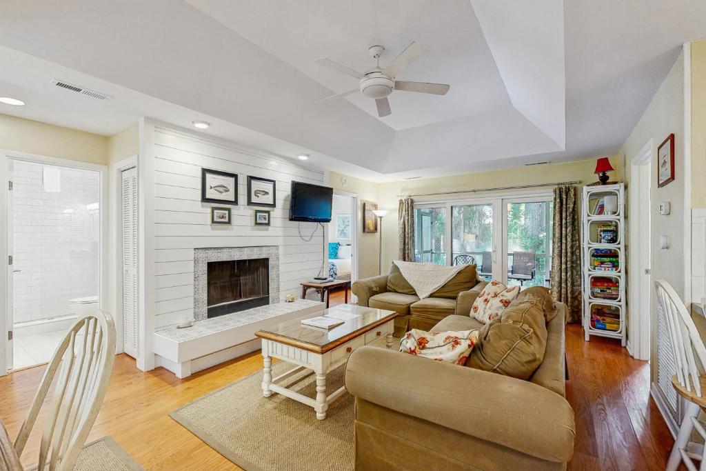 ein Wohnzimmer mit Sofa und Kamin in der Unterkunft 1038 Sparrow Pond in Kiawah Island