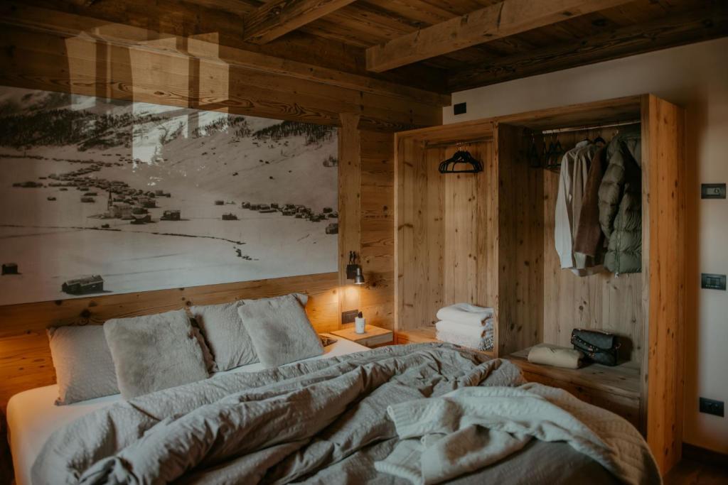 Stalina Alpine Chalet في ليفينو: غرفة نوم بها سرير ولوحة على الحائط