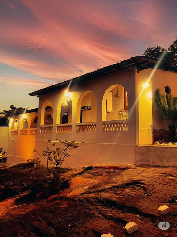 a white house with a sunset in the background at Pousada Raizes de Lencóis in Lençóis