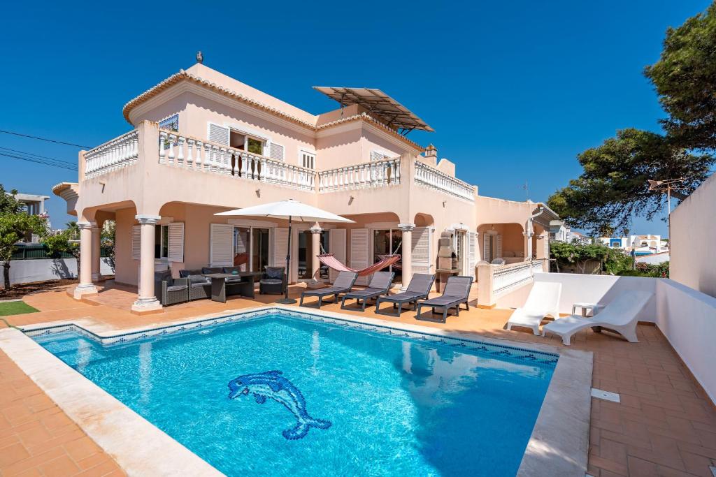 una villa con piscina di fronte a una casa di Poiso da Águia a Carvoeiro