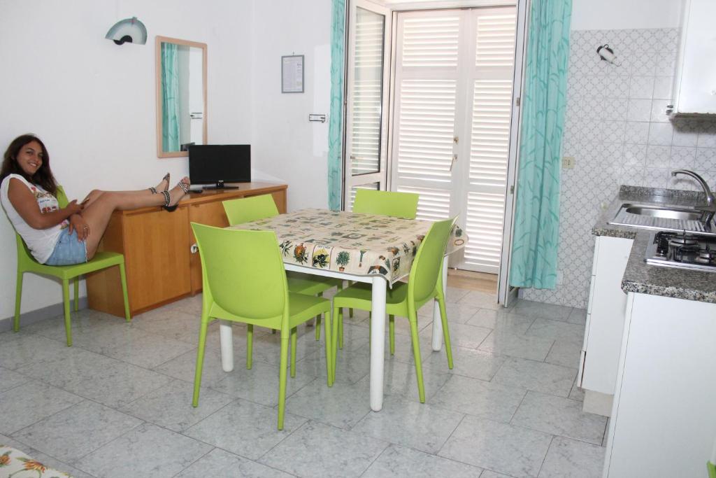 a woman sitting on a table in a kitchen at Aparthotel Villa Marinù in Ischia