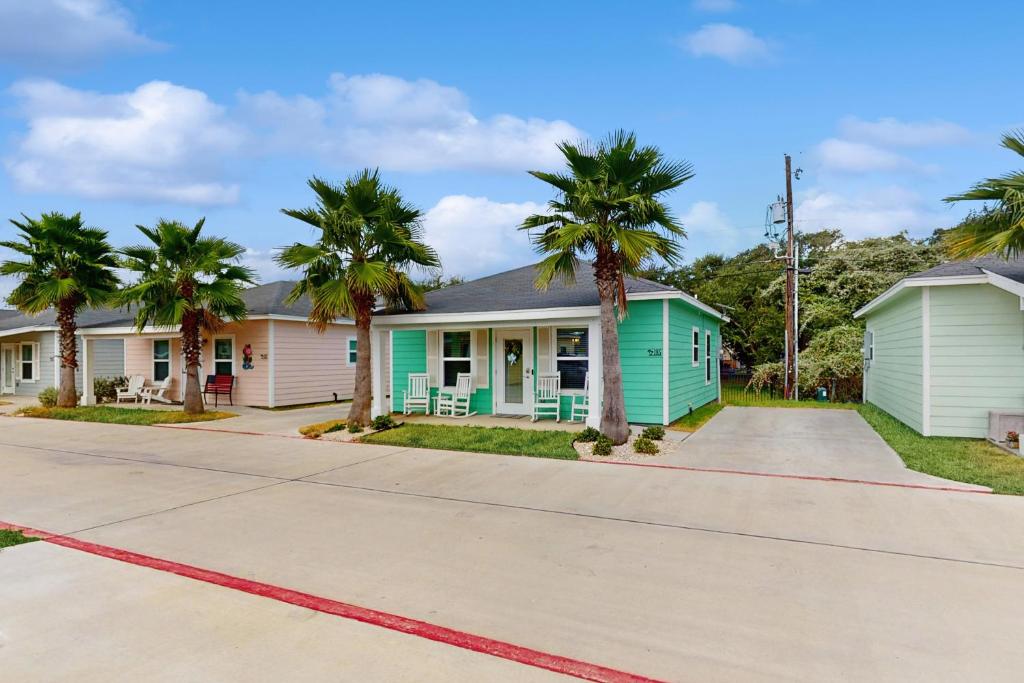 een rij huizen met palmbomen voor de deur bij Seaglass Cottage in Rockport