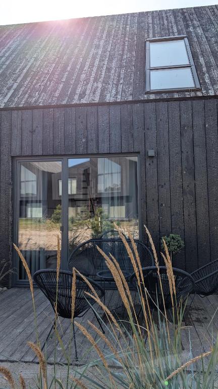 a black house with a window and a bench at Svencele K12 in Svencelė