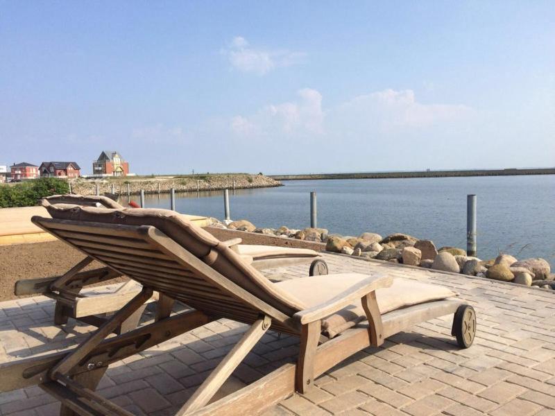 a lounge chair sitting next to a body of water at Ferienhaus Wellenreiter in Kappeln